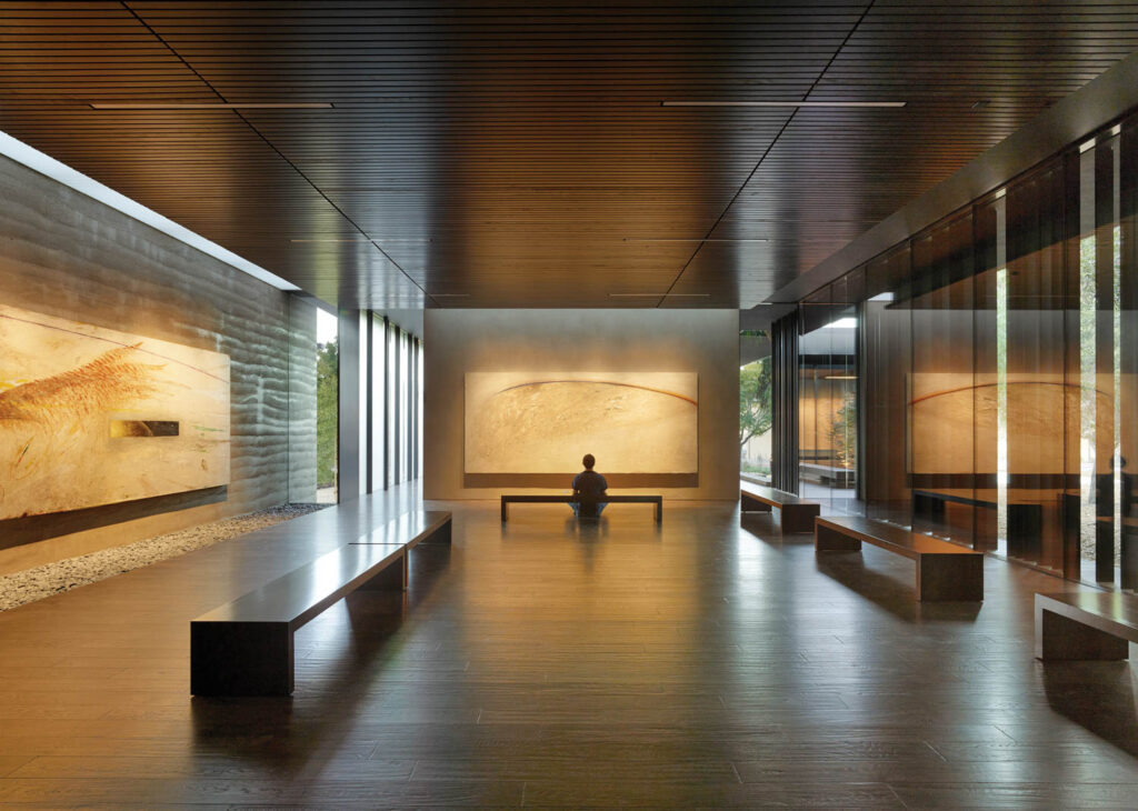 a person meditating in a minimalist room with gold hues