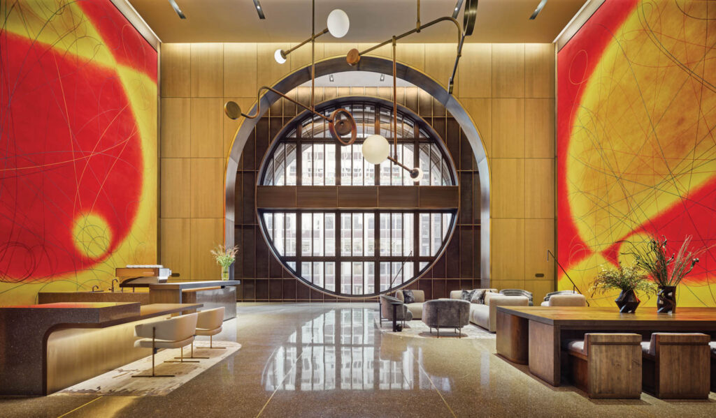 an oculus in the grand hall of 550 Madison, with orange and red murals flanking it