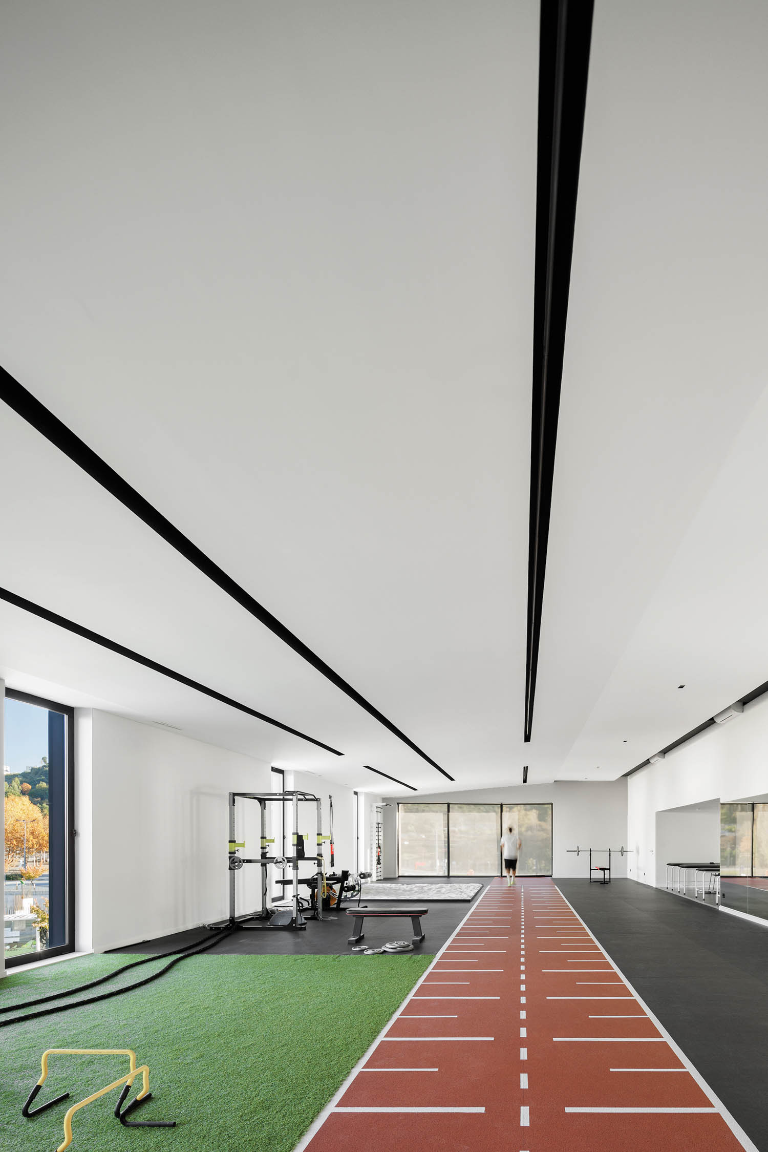 gym room with brown and black flooring and fake turf