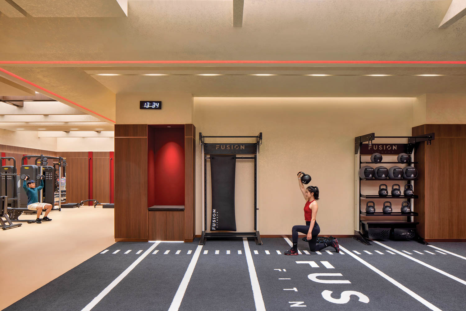 woman lifting weights in the corner of gym