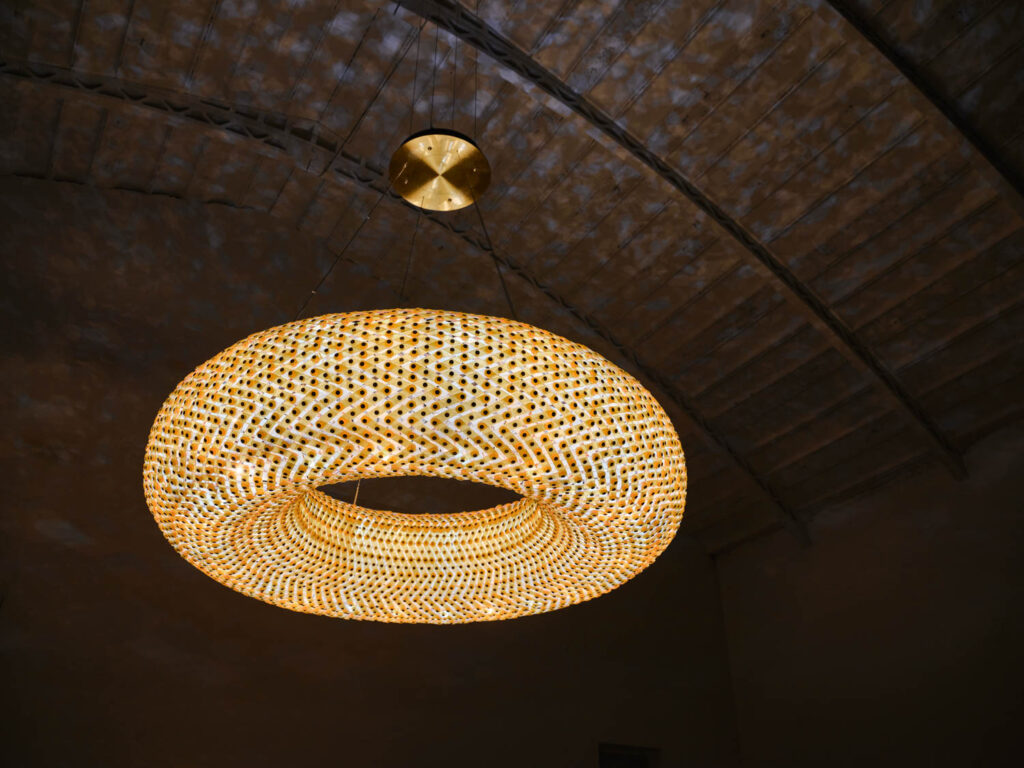 lit up circular sculpture hanging from the ceiling