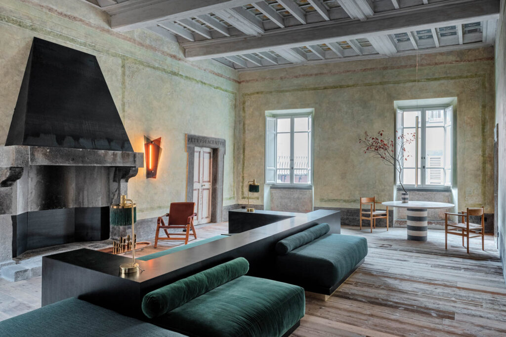 living room with dark green chaises and rustic features