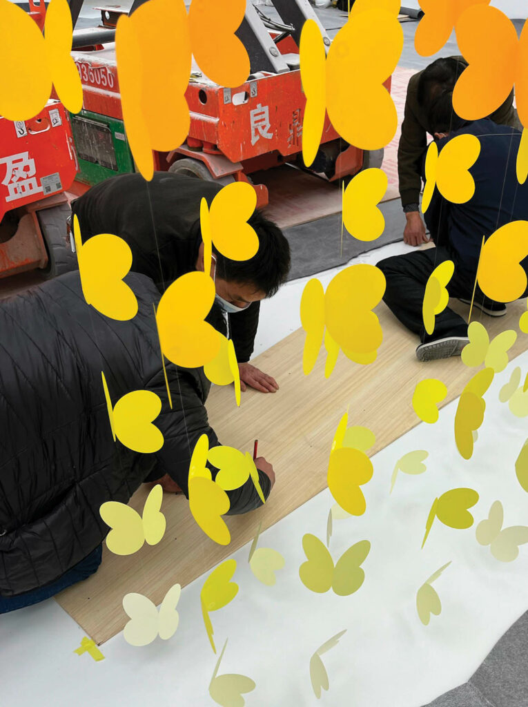 people working on yellow butterflies and drawing things out