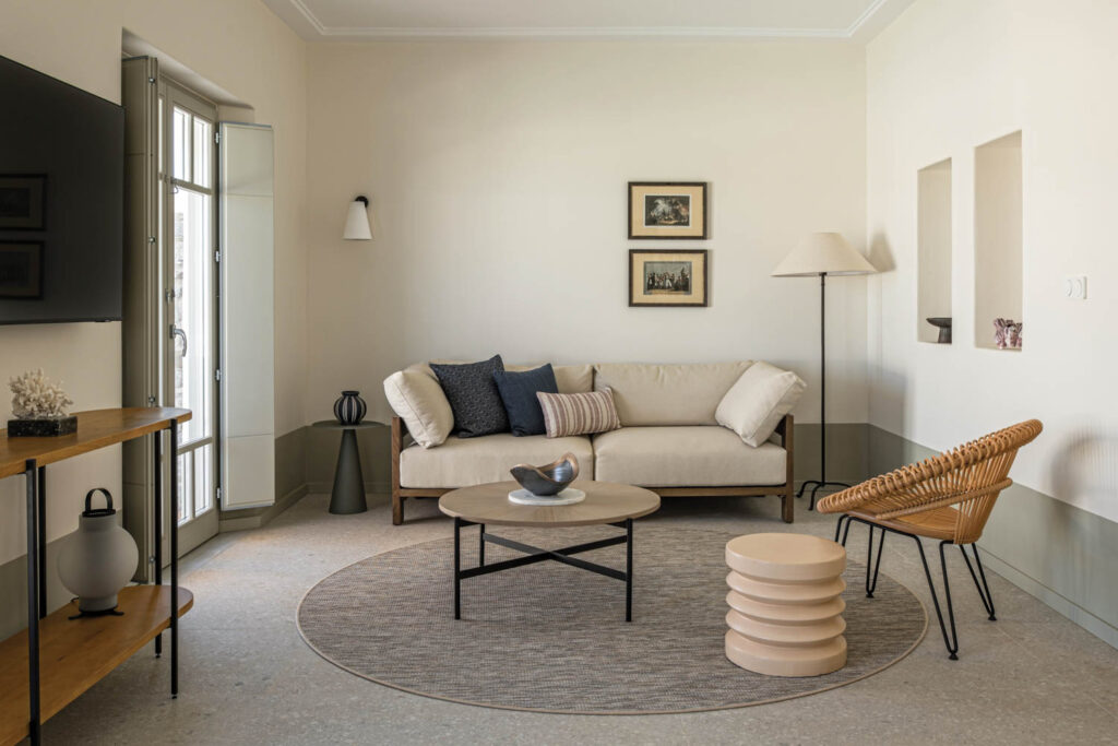 living room area with white couch, circle rug and pictures on wall