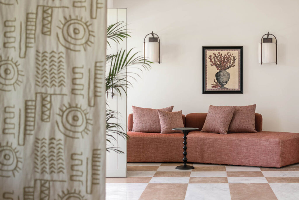 sitting room with rose pink sofa and patterned drapes