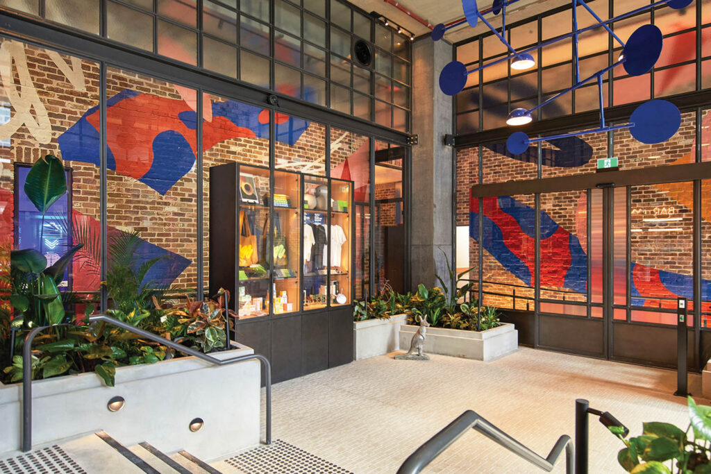 corner of office with glass paneled walls with blue and red art