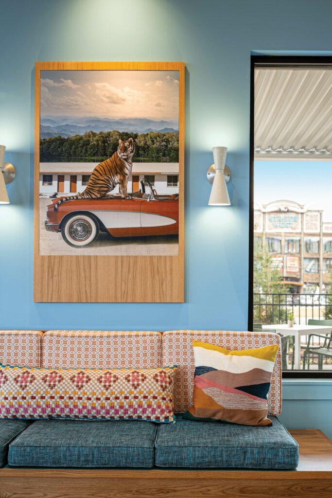 sitting area inside The Wayback room suite with bright blue walls and eclectic painting and furnishings