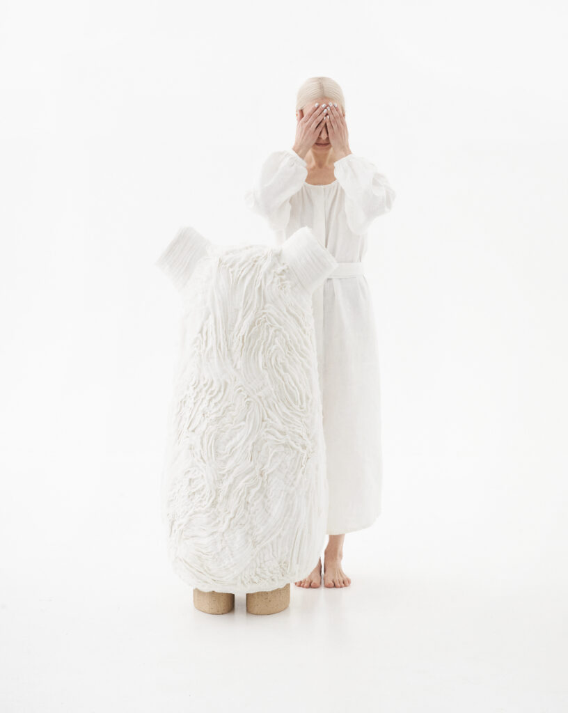 Woman closing her eyes next to a fuzzy floor lamp